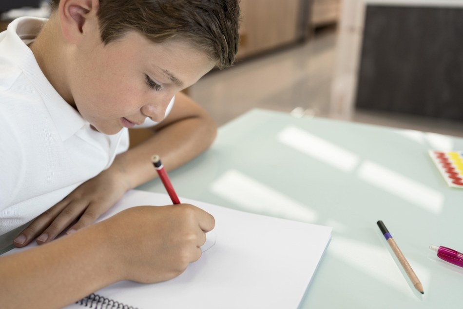 positive young boy doing his homework